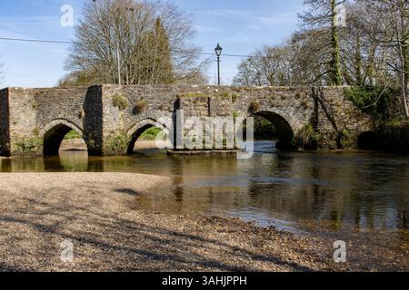 Ancien pont médiéval à Lostwithiel Cornwall par un matin de printemps lumineux avec des reflets dans la rivière Fowey Banque D'Images