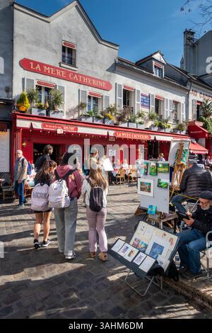 France, Paris, Montmartre, place du Tertre, artiste montrant des œuvres sur le trottoir face au restaurant la Mere Catherine Banque D'Images