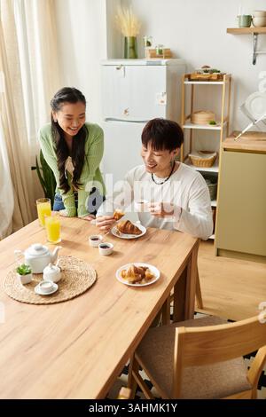 Des moments joyeux se déroulent comme un jeune couple profite d'un délicieux petit déjeuner ensemble à la maison. Banque D'Images
