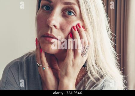 Belle femme de milieu d'âge montrant la manucure rouge de shellac sur les ongles . Banque D'Images