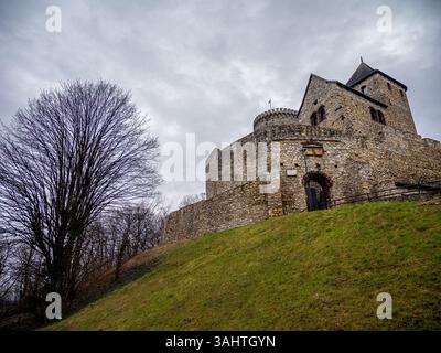 Un très grand château de pierre est majestueusement assis au sommet d'une colline herbeuse à Bedzin, en Pologne Banque D'Images