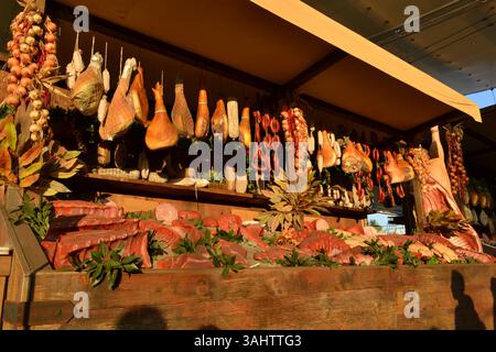 Des étals de marché italiens traditionnels situés le long de la rue Decumano créée par Dante Ferretti. Les produits de boucherie sur eux semblent réels. Lumière vive du soleil Banque D'Images