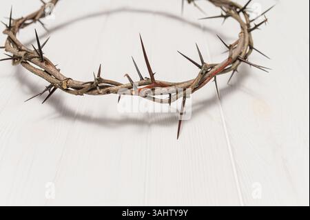 Couronne d'épines projetant une ombre distincte sur un fond blanc de pâques, créant une image symbolique de la souffrance, du sacrifice et de l'espace de copie de souvenir Banque D'Images