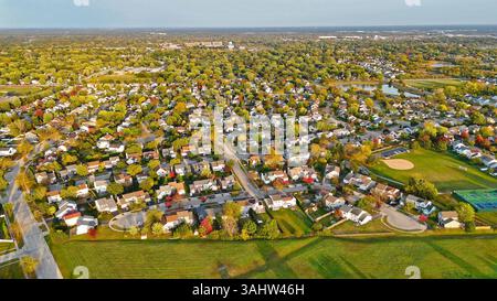 Vue aérienne large de la communauté de banlieue. Vue aérienne d'une vaste communauté de banlieue avec des maisons, des rues bordées d'arbres, des espaces verts ouverts, et un Banque D'Images