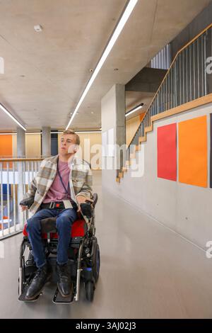 Homme en fauteuil roulant dans le couloir du bureau Banque D'Images