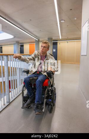 Homme en fauteuil roulant dans le couloir du bureau Banque D'Images