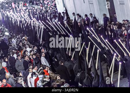 Séville, Espagne, 9 avril 2009, Nazarenos de Gran Poder portent des bougies tout en se déplaçant dans une rue étroite remplie de spectateurs pendant la semaine Sainte au se Banque D'Images
