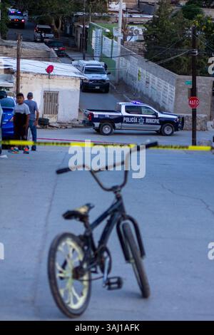 Des enquêteurs légistes et des policiers examinent une scène de crime impliquant un véhicule noir à Ciudad Juárez, au Mexique. Banque D'Images