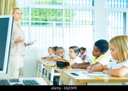 Élèves préadolescents ciblés étudiant en classe avec une enseignante Banque D'Images