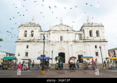 Vendeurs de rue, pigeons volants et gens devant la cathédrale Léon. Leon, Nicaragua. Banque D'Images