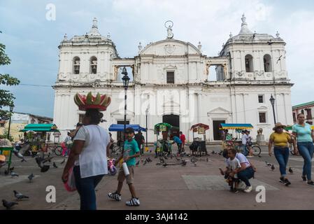 Vendeurs de rue, pigeons volants et gens devant la cathédrale Léon. Leon, Nicaragua. Banque D'Images