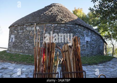 14 octobre 2015 - O Cebreiro, Galice/Province de Lugo, Espagne - O Cebreiro, Espagne : bâtons de marche à vendre devant une palloza traditionnelle typique de la région de Serra dos Ancares en Galice. Initialement destinées à abriter le bétail, les habitations ont des murs rustiques en pierre et un toit conique incliné composé de tiges de seigle. (Crédit image : © Paul Gordon via ZUMA Wire) Banque D'Images