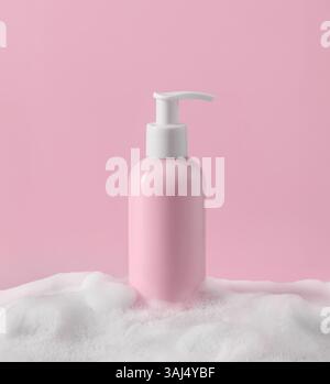 Un flacon à pompe rose élégant et chic entouré d'un fond de mousse souple, idéal pour les produits de beauté et de soin de la peau Banque D'Images