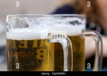 Deux tasses à bière mousseuses dans un bar Banque D'Images