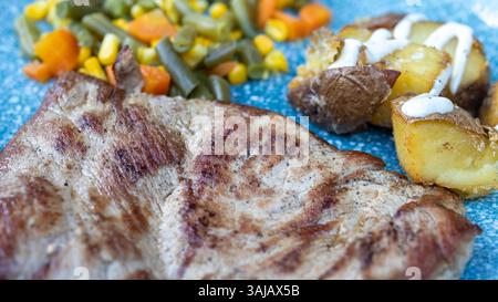 Steak grillé avec pommes de terre et légumes mélangés Banque D'Images