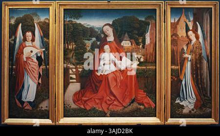 Cette peinture triptyque représente la Vierge à l'enfant au centre, flanquée de deux anges jouant de la musique, créée par le Maître du feuillage brodé (vers 1490). L'œuvre est conservée au Palais des Beaux-Arts de Lille, reflétant des thèmes religieux et l'art médiéval néerlandais. Banque D'Images