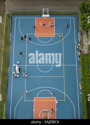 Vue aérienne d'un peuple jouant sur un terrain de basket-ball dans la rue dans l'environnement urbain Banque D'Images