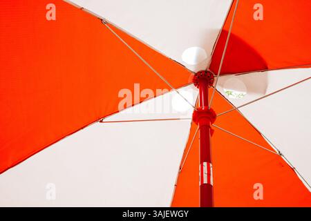 Parapluie orange vif offre de l'ombre sur les journées ensoleillées à l'extérieur Banque D'Images