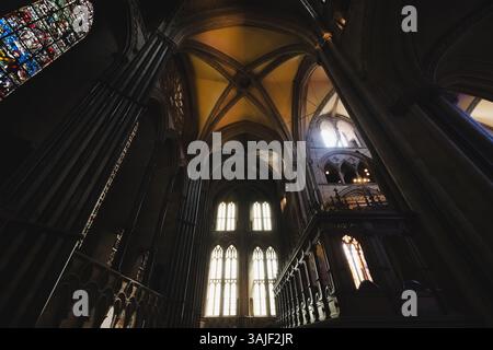 L'intérieur atmosphérique de la cathédrale historique de Durham présente des arches gothiques, des vitraux, et une ombre et une lumière spectaculaires à travers l'église Banque D'Images