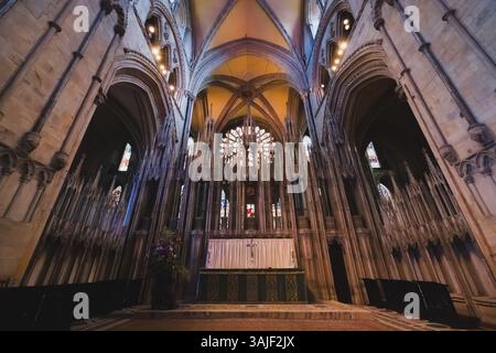 L'intérieur orné de la cathédrale de Durham présente un grand autel, des plafonds voûtés et des vitraux vibrants, mettant en valeur son architecture normande historique Banque D'Images