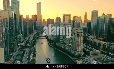 Chicago Illinois 17.10.2024. Fleuve Chicago entouré de gratte-ciel au coucher du soleil. Vue aérienne de la rivière Chicago serpentant à travers le centre-ville, entouré Banque D'Images