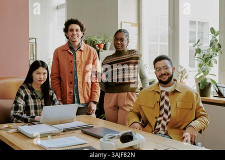 Portrait de jeunes programmeurs adultes biraciaux posant ensemble pour la photo dans le bureau de la société INFORMATIQUE Banque D'Images