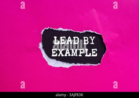 Dirigez par un message d'exemple écrit sur du papier rose déchiré déchiré sur fond noir. Symbole de la direction conceptuelle par exemple. Copier l'espace. Banque D'Images