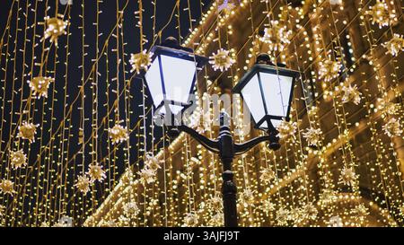 Lumières de Noël illuminant une rue la nuit Banque D'Images