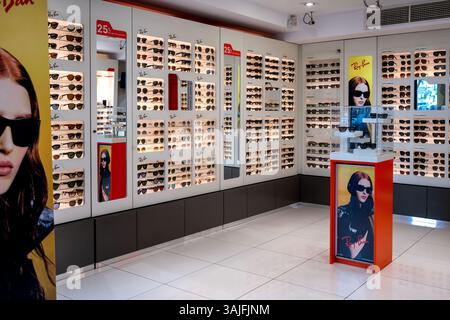 Sliema, Malte- 04.09.2025 : Bright Ray-Ban magasin de lunettes de vue avec des affichages muraux de lunettes de soleil de diverses marques populaires et des affiches promotionnelles Banque D'Images