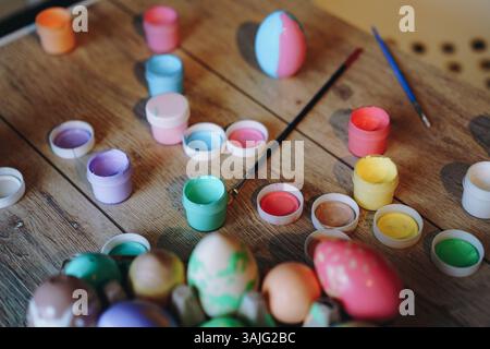 oeufs colorés faits à la main et peinture acrylique. Flatlay de Pâques. Image avec mise au point sélective et grain de film Banque D'Images