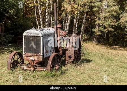 Tracteur rouillé antique dans un dégagement forestier Banque D'Images