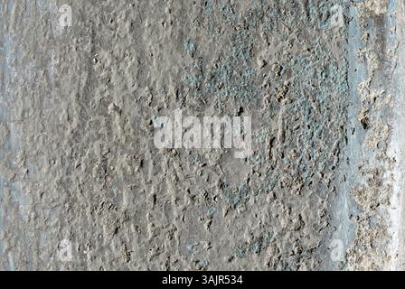 Gros plan d'un mur déchiré avec une surface tachée de peinture blanche écaillée et une texture de béton profonde Banque D'Images