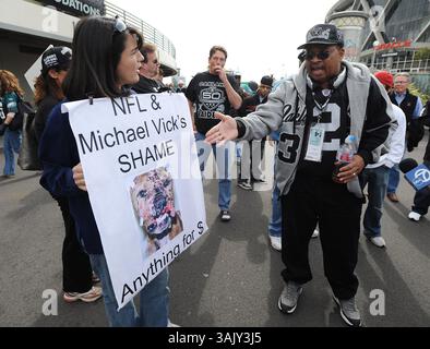 (De gauche à droite) le manifestant Deniz Bolbo, de Redwood City, se dispute avec le fan des Raiders Ed Willis, de Tracy, devant les Oakland Raiders vs Philadelphia Eagles le dimanche 18 octobre 2009 au Oakland Coliseum à Oakland, Calif. Environ 20 personnes se tenaient debout avec des pancartes protestant contre l'arrivée du quarterback de la NFL Michael Vick. Vick a purgé 18 mois de prison pour son implication dans un réseau illégal de combat de chiens. (Jose Carlos Fajardo/personnel) Banque D'Images