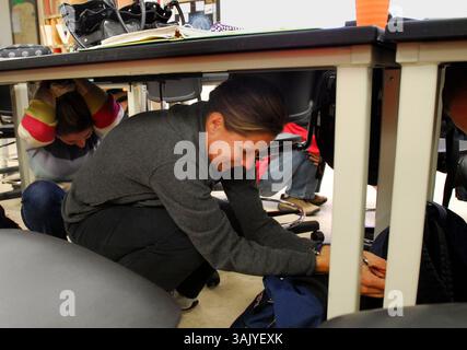 Theresa Galus-Gurten canards sous sa table de laboratoire lors de son cours de technologie radiologique au Collège Canada à Redwood City, Calif, le jeudi 15 octobre 2009. Le collège a pris part au Great California Shakeout, un exercice sismique qui a coïncidé avec le 20e anniversaire du tremblement de terre de Loma Prieta. (Dan Honda/personnel) Banque D'Images