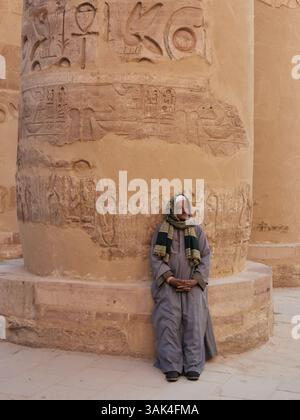 Guide solitaire au temple de Karnak à Louxor attend patiemment quelques touristes pour montrer autour. Banque D'Images