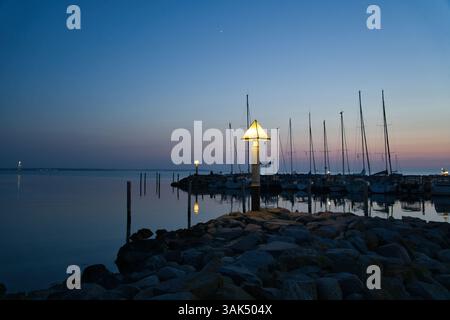 Port sur l'île de Poel. Bateaux à voile, phare et éclairage de lanterne à Blue Hour. Paysage sur la côte de la mer Baltique Banque D'Images