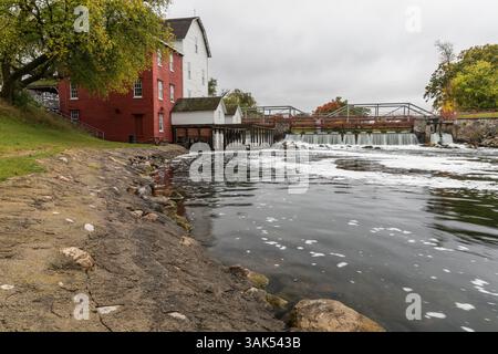 Un vieux moulin à côté d'un barrage sur une rivière en automne. Banque D'Images