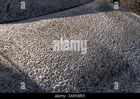 Mousse pénétrante active blanche sur la carrosserie, lavage de voiture dans un lave-auto sans contact, produits chimiques pour voiture Banque D'Images