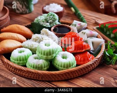 Des gâteaux indonésiens traditionnels colorés, également connus sous le nom de 'Kue basah', sont exposés sur une poêle en bambou tissé avec une couche de feuilles de bananier. Idéal pour culinaire Banque D'Images