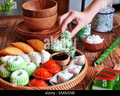Des gâteaux indonésiens traditionnels colorés, également connus sous le nom de 'Kue basah', sont exposés sur une poêle en bambou tissé avec une couche de feuilles de bananier. Idéal pour culinaire Banque D'Images