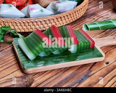 Des gâteaux indonésiens traditionnels colorés, également connus sous le nom de 'Kue basah', sont exposés sur une poêle en bambou tissé avec une couche de feuilles de bananier. Idéal pour culinaire Banque D'Images