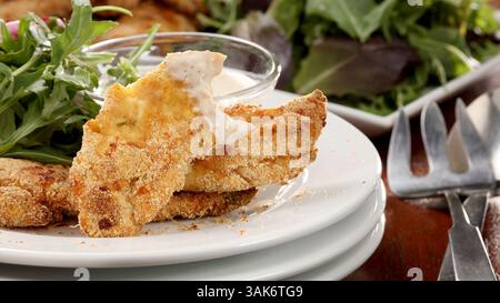 28 février 2017 - Chicago, il, États-Unis - les tendres de poulet au parmesan, adaptées du livre de Diana Henry ''simple'', sont servies sur des légumes verts mélangés avec une vinaigrette Caesar au yaourt. (Crédit image : © Michael Tercha/TNS via ZUMA Wire) Banque D'Images