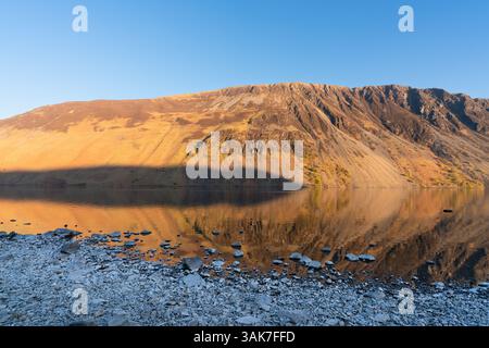 Middle Fell, de l'autre côté du lac, projette son ombre sur les chapes de Wastwater Banque D'Images