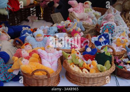 Poupées colorées faites à la main avec des visages mignons et des vêtements colorés exposés dans des paniers en osier à un étal de marché en Hongrie Banque D'Images