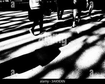 Longues ombres du soir des gens à une gare Banque D'Images