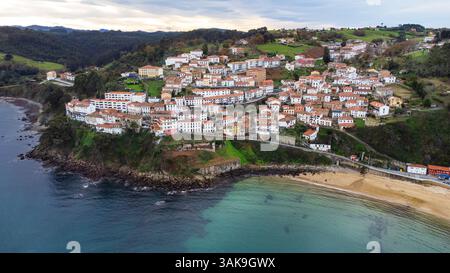 Vue aérienne depuis le côté océan de Llastres, une vieille ville avec des maisons blanches et des toits de tuiles rouges, considérée comme l'un des plus beaux villages d'Espagne. Banque D'Images