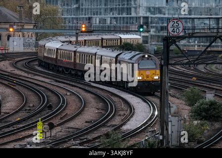 Londres, Royaume-Uni. 12 avril 2025. Un train Pullman britannique Belmond retourne à la gare Victoria après une excursion d'une journée avec la centrale électrique historique de Battersea en arrière-plan. Une loi d'urgence pour sauver British Steel de la fermeture imminente a été approuvée par le gouvernement tard samedi après-midi. La masse ferme produit de l'acier vierge et est un fournisseur majeur pour les chemins de fer britanniques. La fermeture de l'usine de Scunthorpe signifierait que le Royaume-Uni serait le seul pays du G7 incapable de fabriquer de l'acier vierge, dépendant plutôt des importations. Crédit : onzième heure photographie/Alamy Live News Banque D'Images