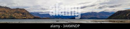 Lac Wanaka, un après-midi nuageux d'été avec une chaîne de montagnes et la ville de Wanaka sur le rivage. Île du Sud, Nouvelle-Zélande Banque D'Images