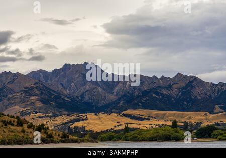 Lac Wanaka, un après-midi nuageux d'été avec une chaîne de montagnes et la ville de Wanaka sur le rivage. Île du Sud, Nouvelle-Zélande Banque D'Images