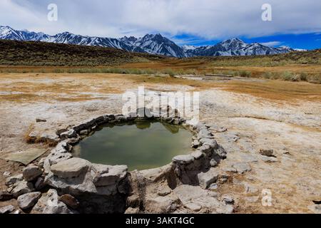 Mammoth Lakes, CA. 10 avril 2025. Une source chaude naturelle avec vue sur les montagnes de la Sierra Nevada près de Mammoth Lakes. Banque D'Images